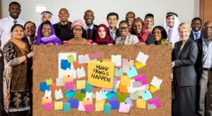 group standing behind a bulletin board with post-its