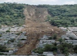 photograph shows fallen earth and collapsed landscape, damaged buildings