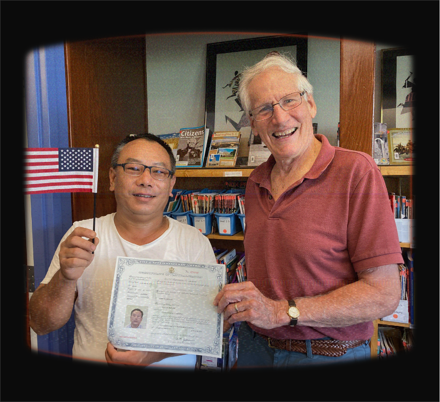 Adult learner holding an American flag and certificate, celebrating with their tutor