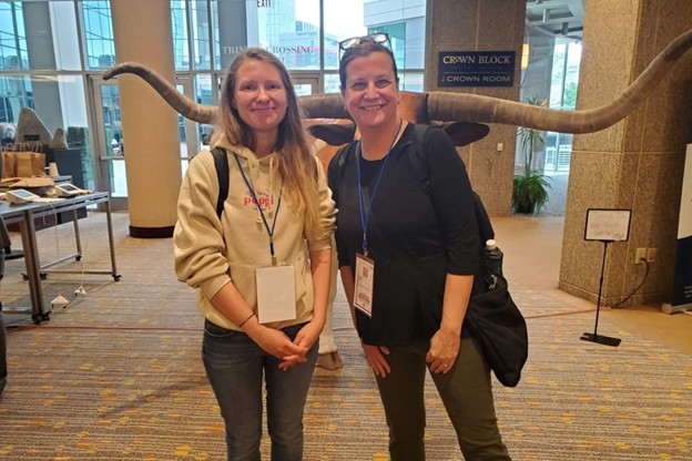 photograph of two cheerful posing in a conference center hallway