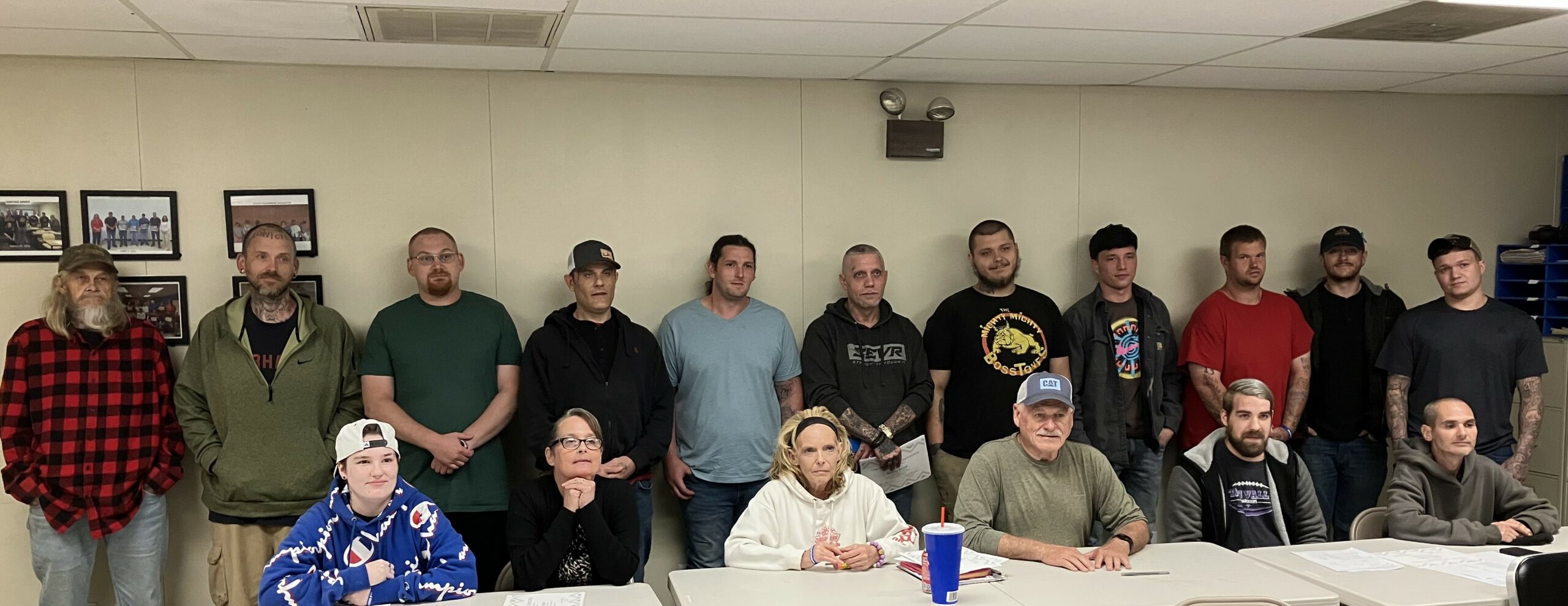 wide photo of a group of adults of diverse ages in a classroom